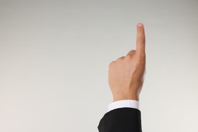 Photo of Man touching something on light grey background, closeup. Space for text
