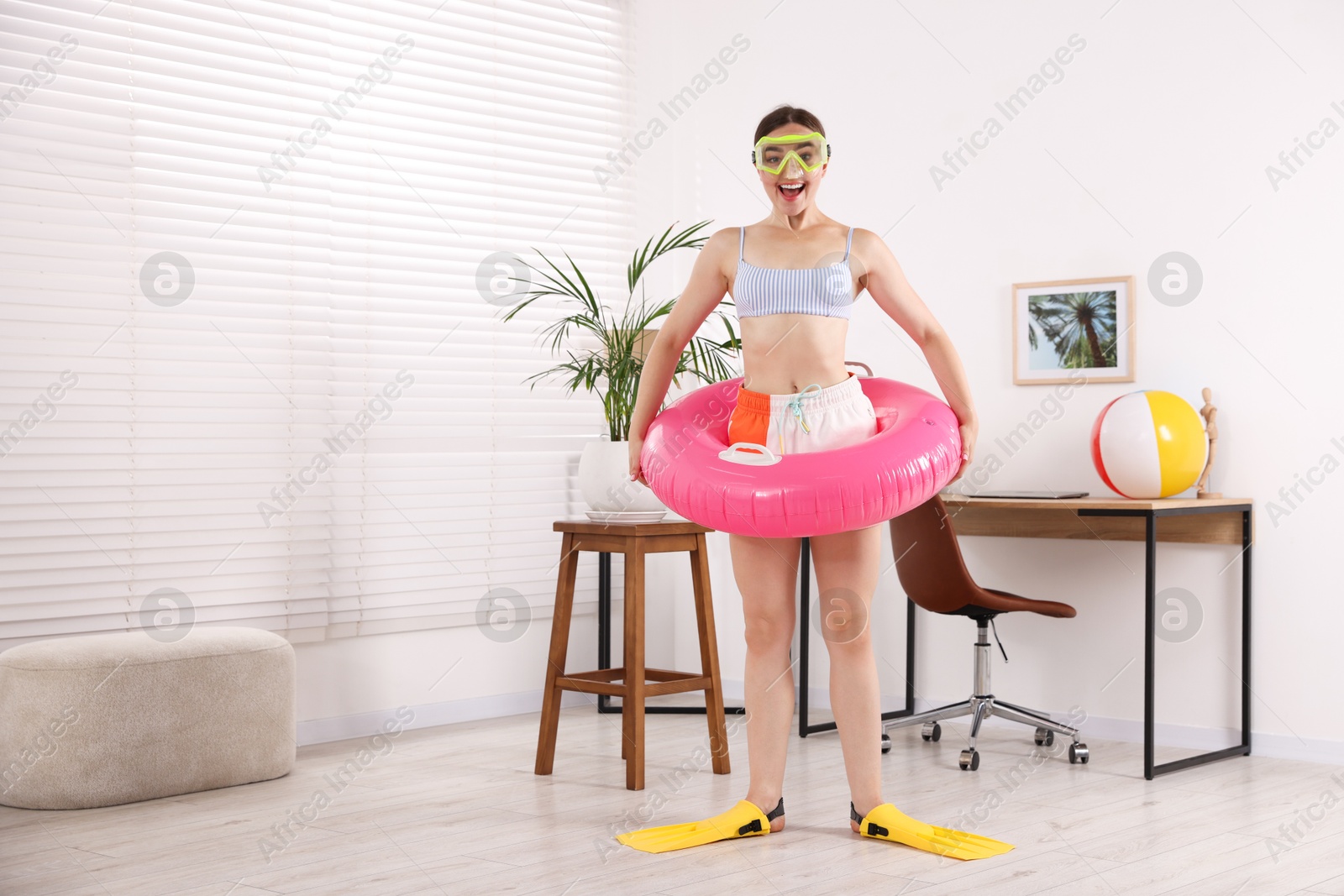 Happy woman in diving mask and flippers with inflatable ring having fun at home, space for text. Dreaming about vacation at sea Photo of Happy woman in diving mask and flippers with inflatable ring having fun at home, space for text. Dreaming about vacation at sea