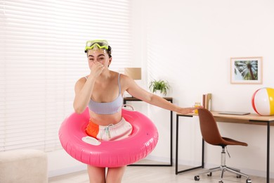 Photo of Woman in diving mask with inflatable ring having fun at home. Dreaming about vacation at sea