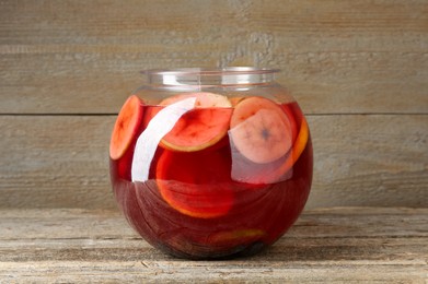 Photo of Tasty fruity punch on wooden table. Refreshing drink