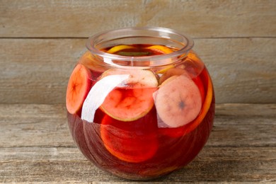 Photo of Tasty fruity punch on wooden table, closeup. Refreshing drink