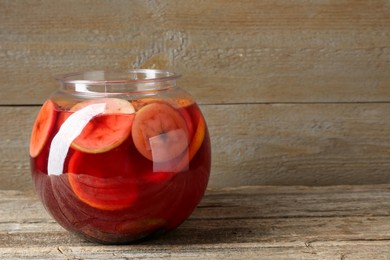 Photo of Tasty fruity punch on wooden table, space for text. Refreshing drink