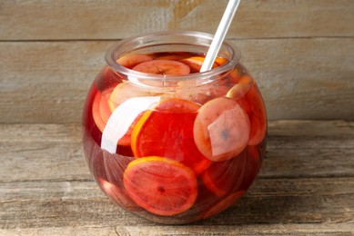 Photo of Tasty fruity punch on wooden table, closeup. Refreshing drink
