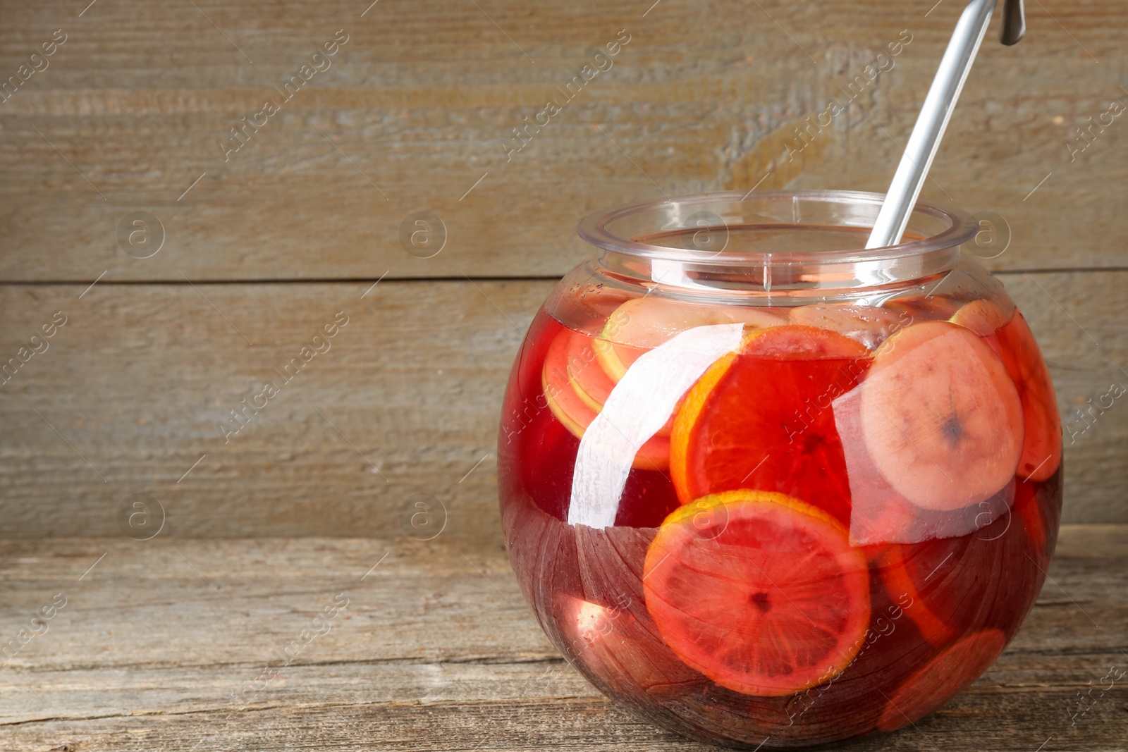 Photo of Tasty fruity punch on wooden table, space for text. Refreshing drink