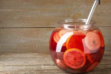Photo of Tasty fruity punch on wooden table, space for text. Refreshing drink