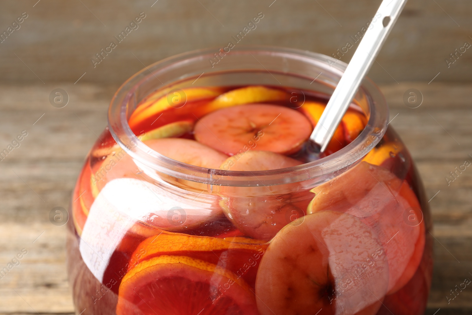 Photo of Tasty fruity punch on wooden table, closeup. Refreshing drink