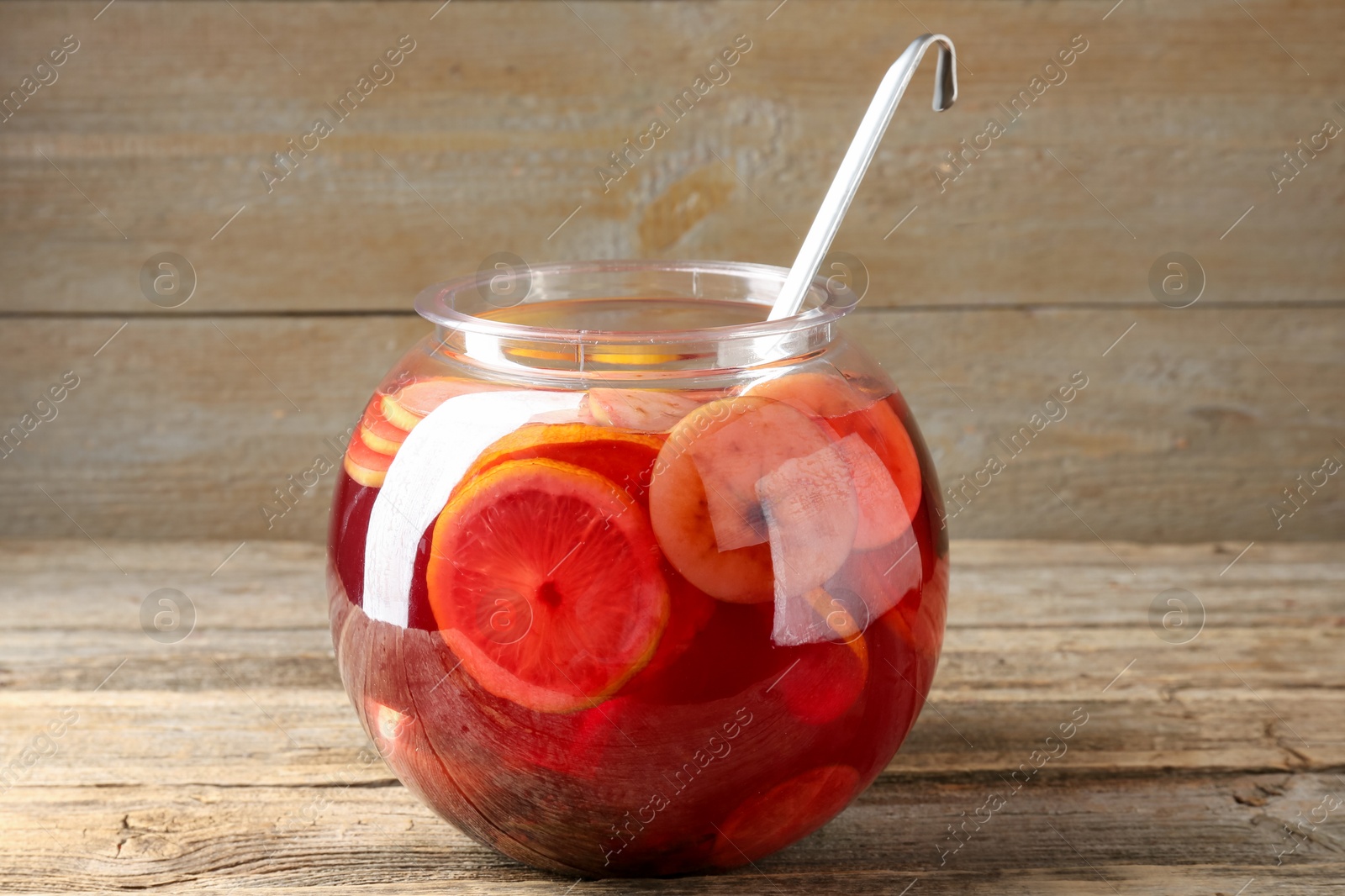 Photo of Tasty fruity punch on wooden table. Refreshing drink