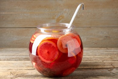 Photo of Tasty fruity punch on wooden table. Refreshing drink