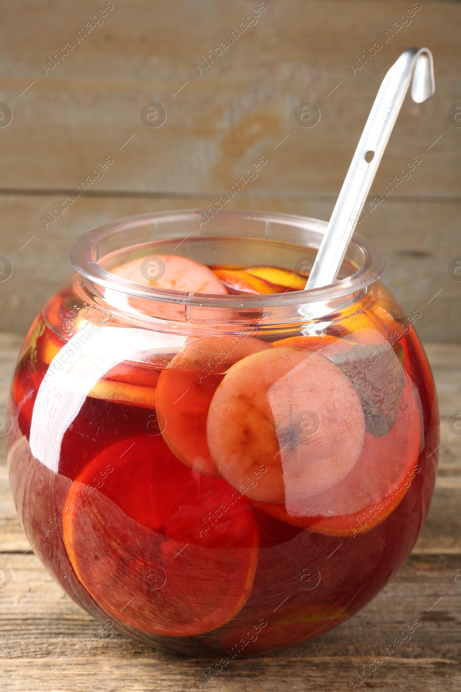Photo of Tasty fruity punch on wooden table, closeup. Refreshing drink