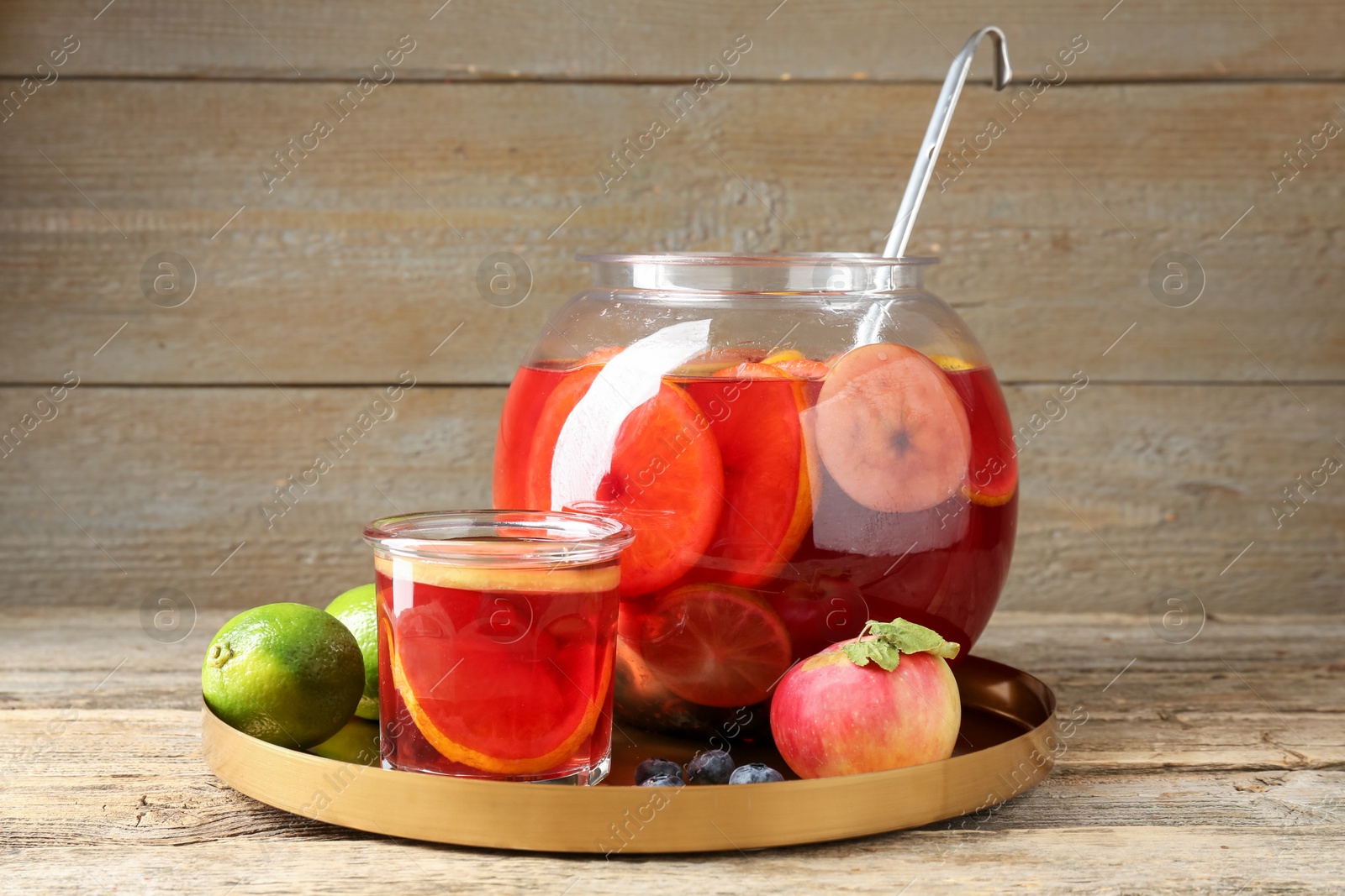 Photo of Tasty punch and fruits on wooden table. Refreshing drink