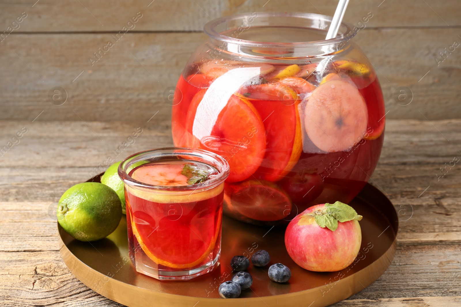 Photo of Tasty punch and fruits on wooden table, closeup. Refreshing drink