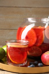 Photo of Tasty punch and fruits on wooden table. Refreshing drink