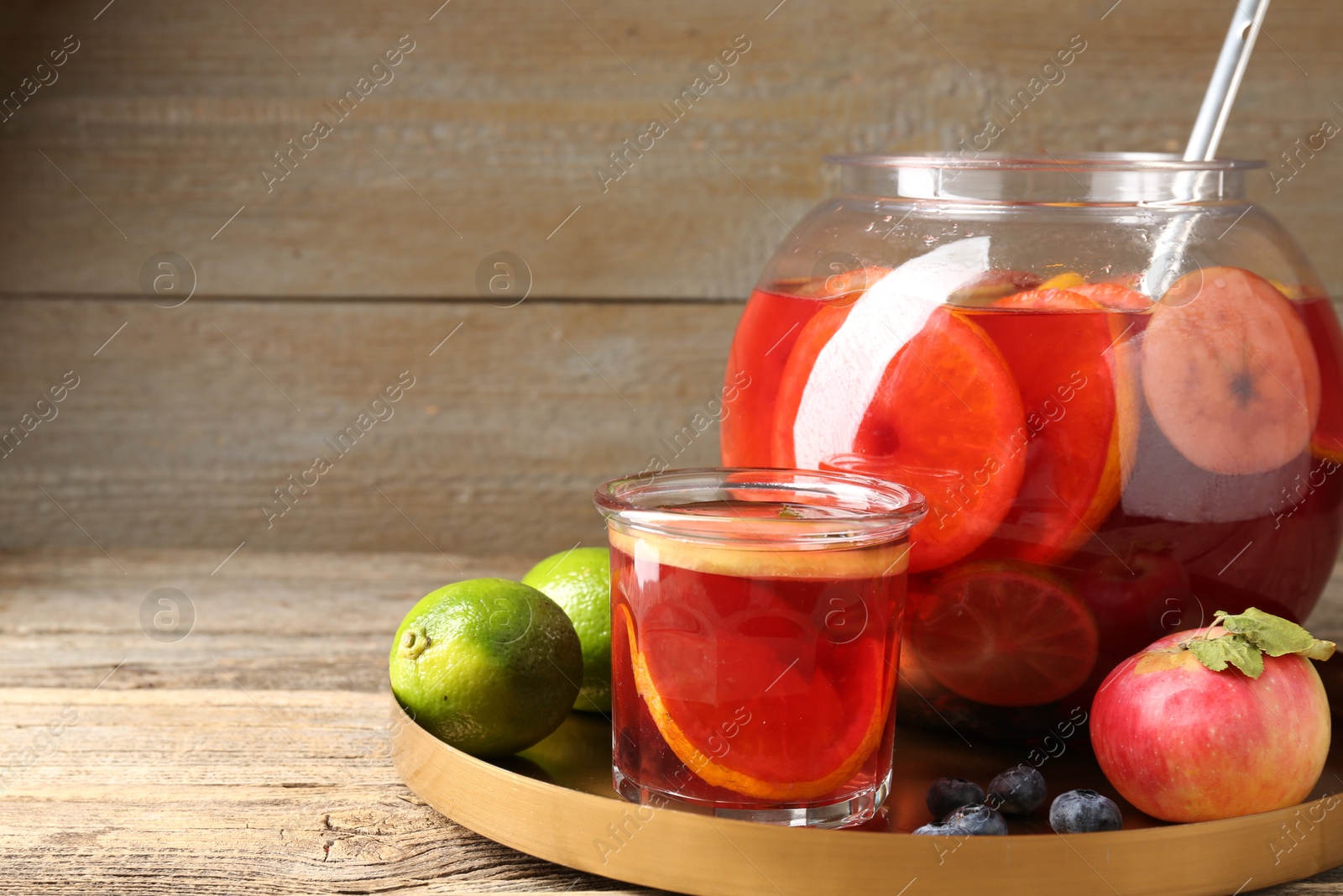 Photo of Tasty punch and fruits on wooden table, closeup. Space for text