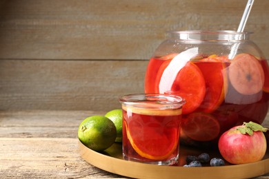 Photo of Tasty punch and fruits on wooden table, closeup. Space for text