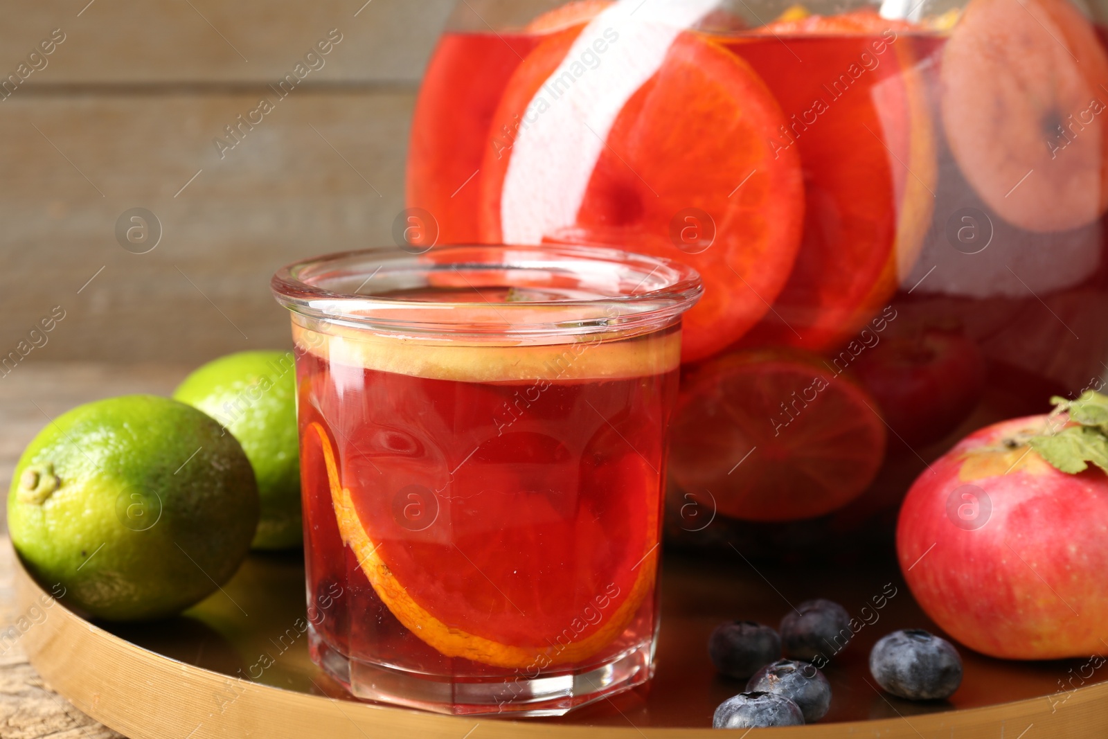 Photo of Tasty punch and fruits on wooden table, closeup. Refreshing drink