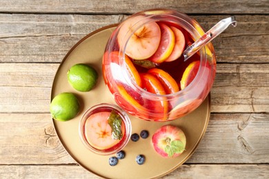 Photo of Tasty punch and fruits on wooden table, top view. Refreshing drink