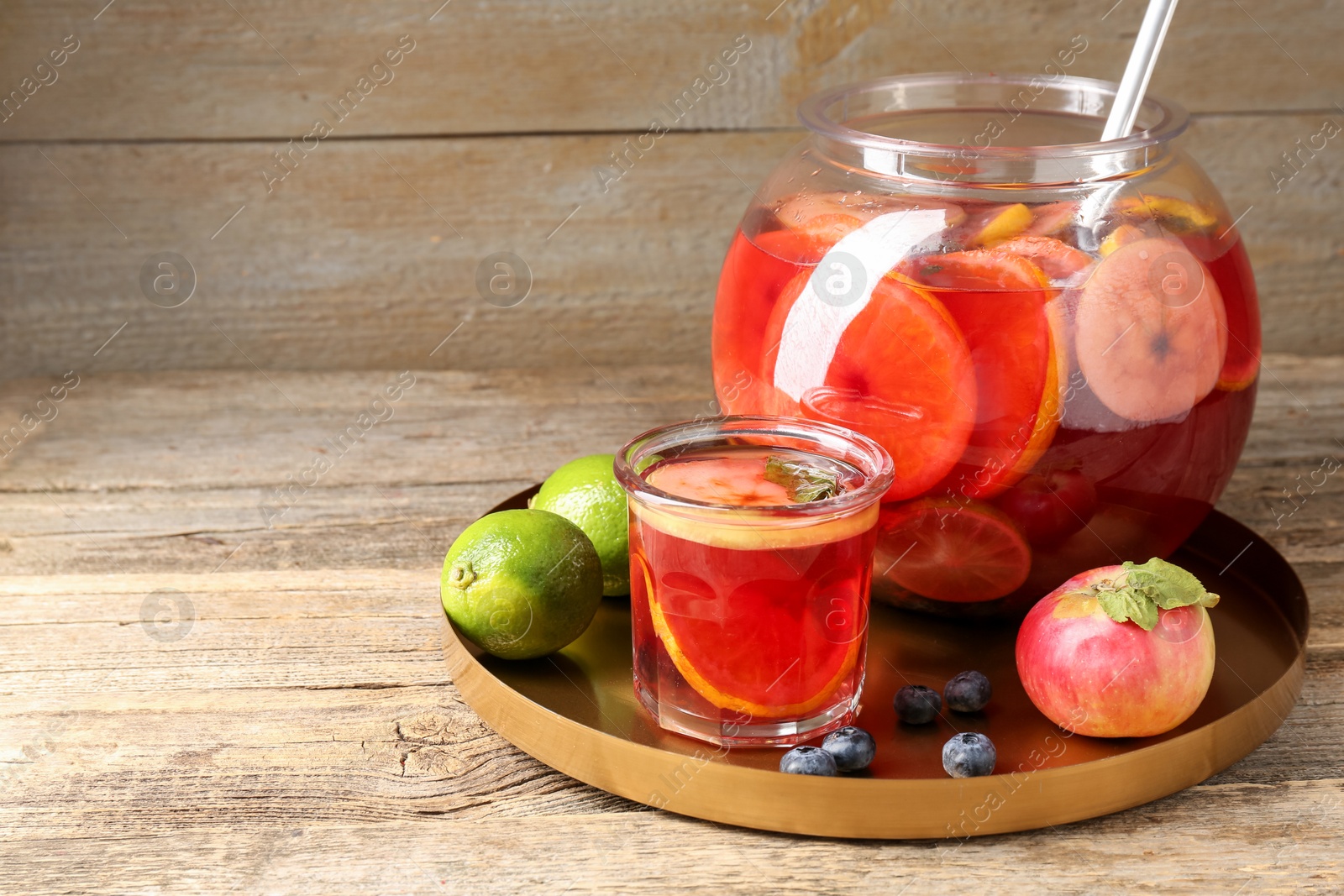 Photo of Tasty punch and fruits on wooden table, space for text. Refreshing drink