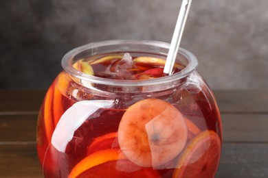 Photo of Tasty fruity punch on wooden table, closeup. Refreshing drink
