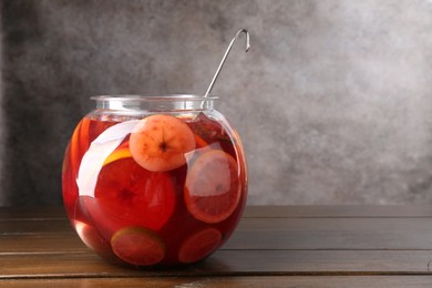 Photo of Tasty fruity punch on wooden table, space for text. Refreshing drink