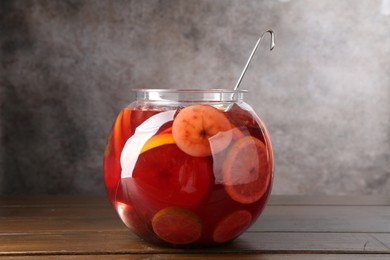 Photo of Tasty fruity punch on wooden table. Refreshing drink