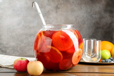 Photo of Tasty punch and fruits on wooden table. Refreshing drink