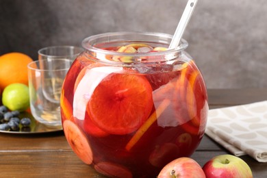 Photo of Tasty punch and fruits on wooden table. Refreshing drink