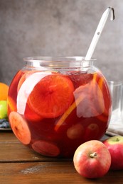 Photo of Tasty punch and fruits on wooden table. Refreshing drink