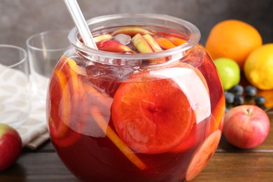 Photo of Tasty punch and fruits on wooden table, closeup. Refreshing drink
