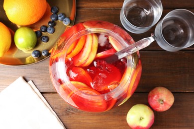 Photo of Tasty punch and fruits on wooden table, flat lay. Refreshing drink