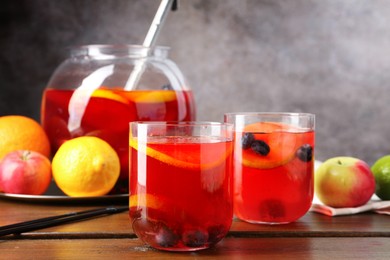 Photo of Tasty punch and fruits on wooden table. Refreshing drink