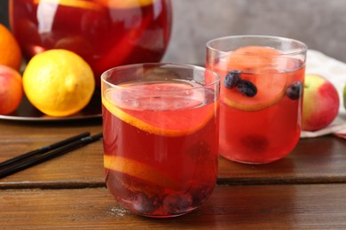 Photo of Tasty punch and fruits on wooden table, closeup. Refreshing drink