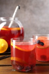 Photo of Tasty punch and fruits on wooden table, closeup. Refreshing drink