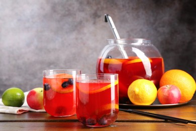 Photo of Tasty punch and fruits on wooden table. Refreshing drink