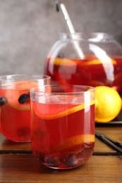 Photo of Tasty punch and fruits on wooden table, closeup. Refreshing drink