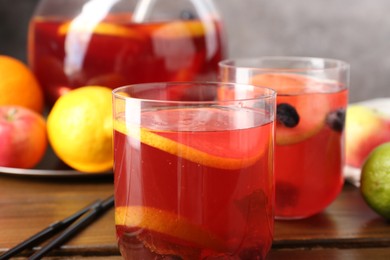 Photo of Tasty punch and fruits on wooden table, closeup. Refreshing drink