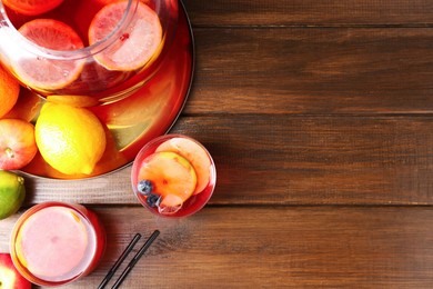 Photo of Tasty punch and fruits on wooden table, flat lay with space for text. Refreshing drink