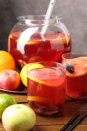 Photo of Tasty punch and fruits on wooden table, closeup. Refreshing drink