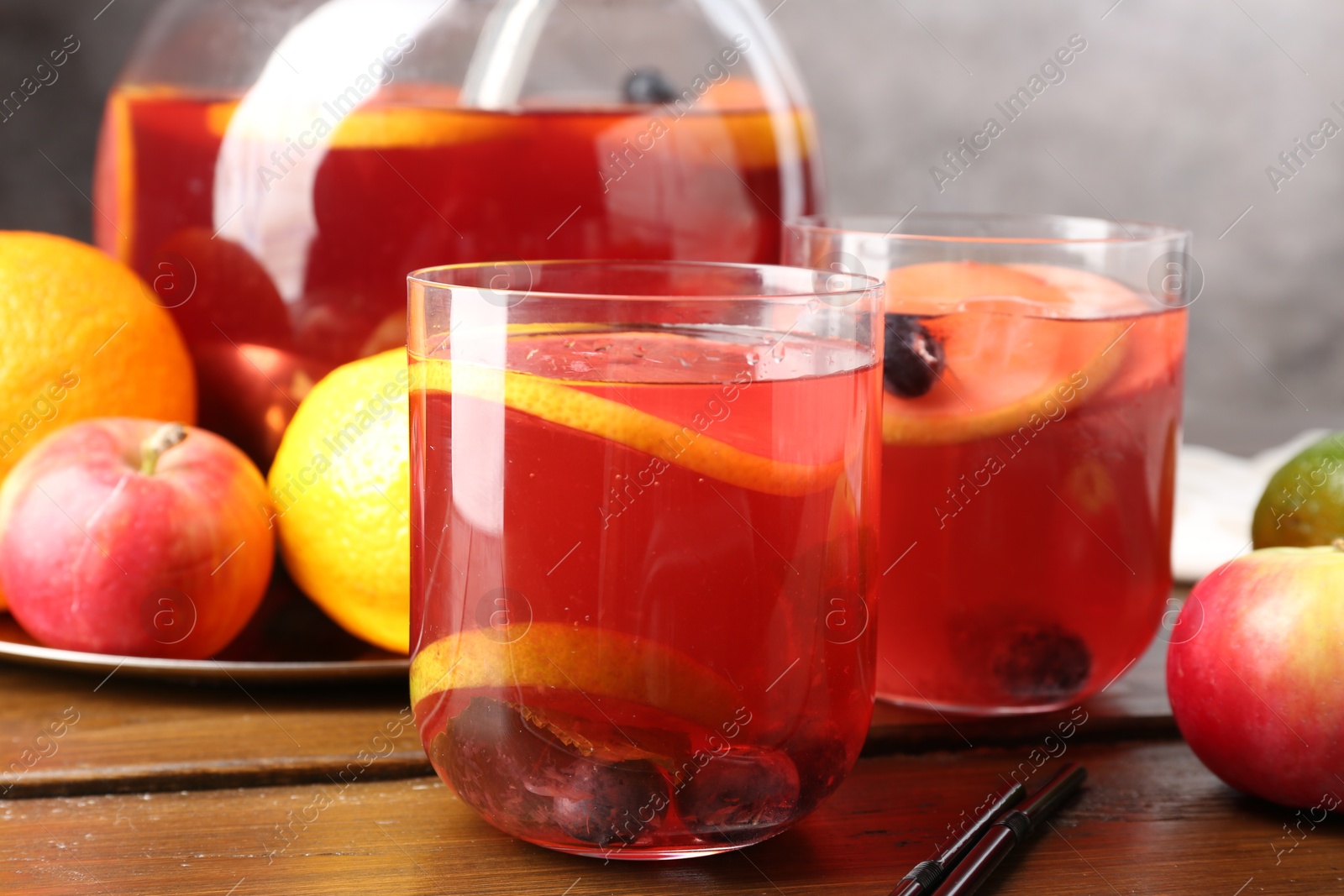 Photo of Tasty punch and fruits on wooden table, closeup. Refreshing drink
