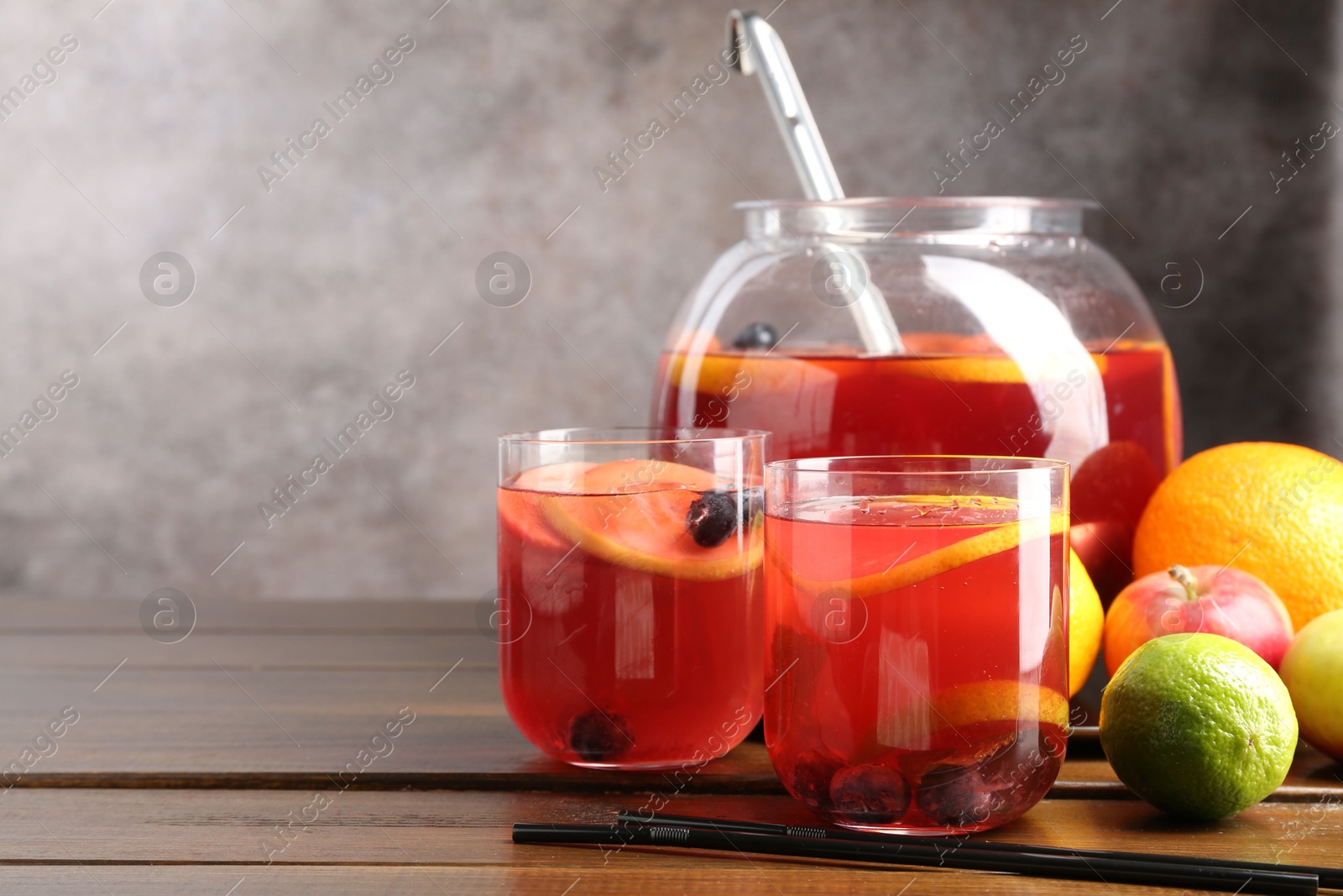 Photo of Tasty punch and fruits on wooden table, space for text. Refreshing drink
