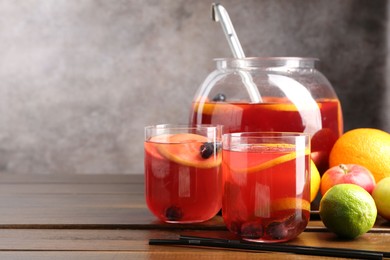 Photo of Tasty punch and fruits on wooden table, space for text. Refreshing drink