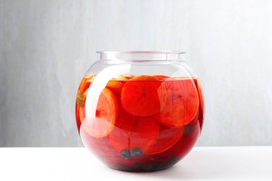 Photo of Tasty fruity punch on white table. Refreshing drink