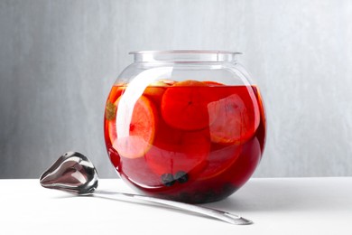 Photo of Tasty fruity punch on white table. Refreshing drink