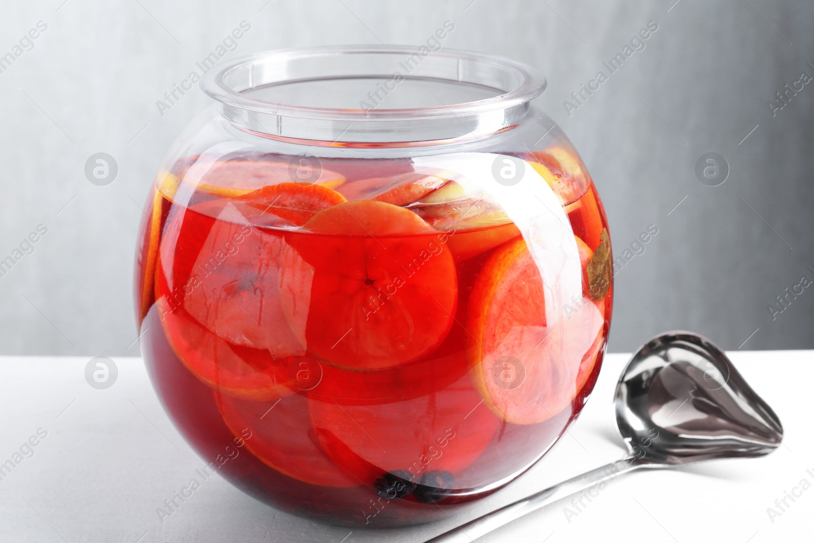 Photo of Tasty fruity punch on white table. Refreshing drink