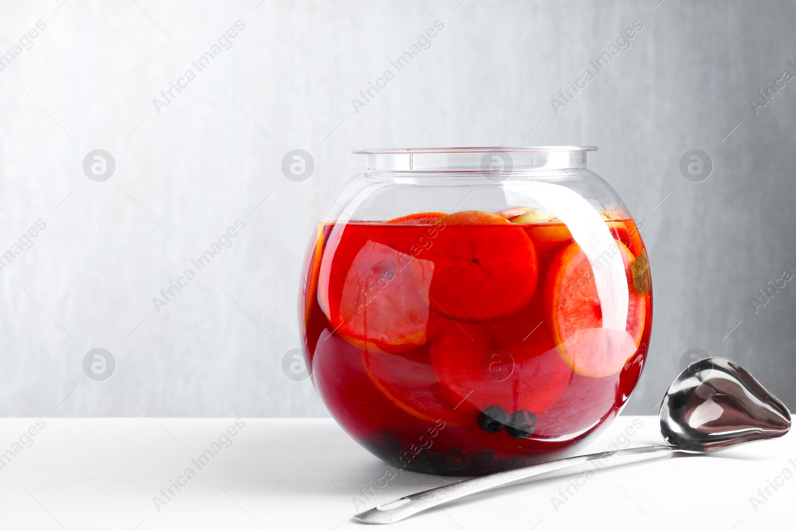 Photo of Tasty fruity punch on white table, space for text. Refreshing drink