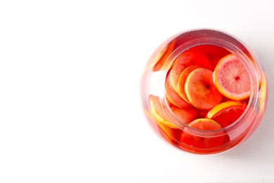 Photo of Tasty fruity punch on white table, top view with space for text. Refreshing drink