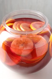 Photo of Tasty fruity punch on white table, closeup. Refreshing drink