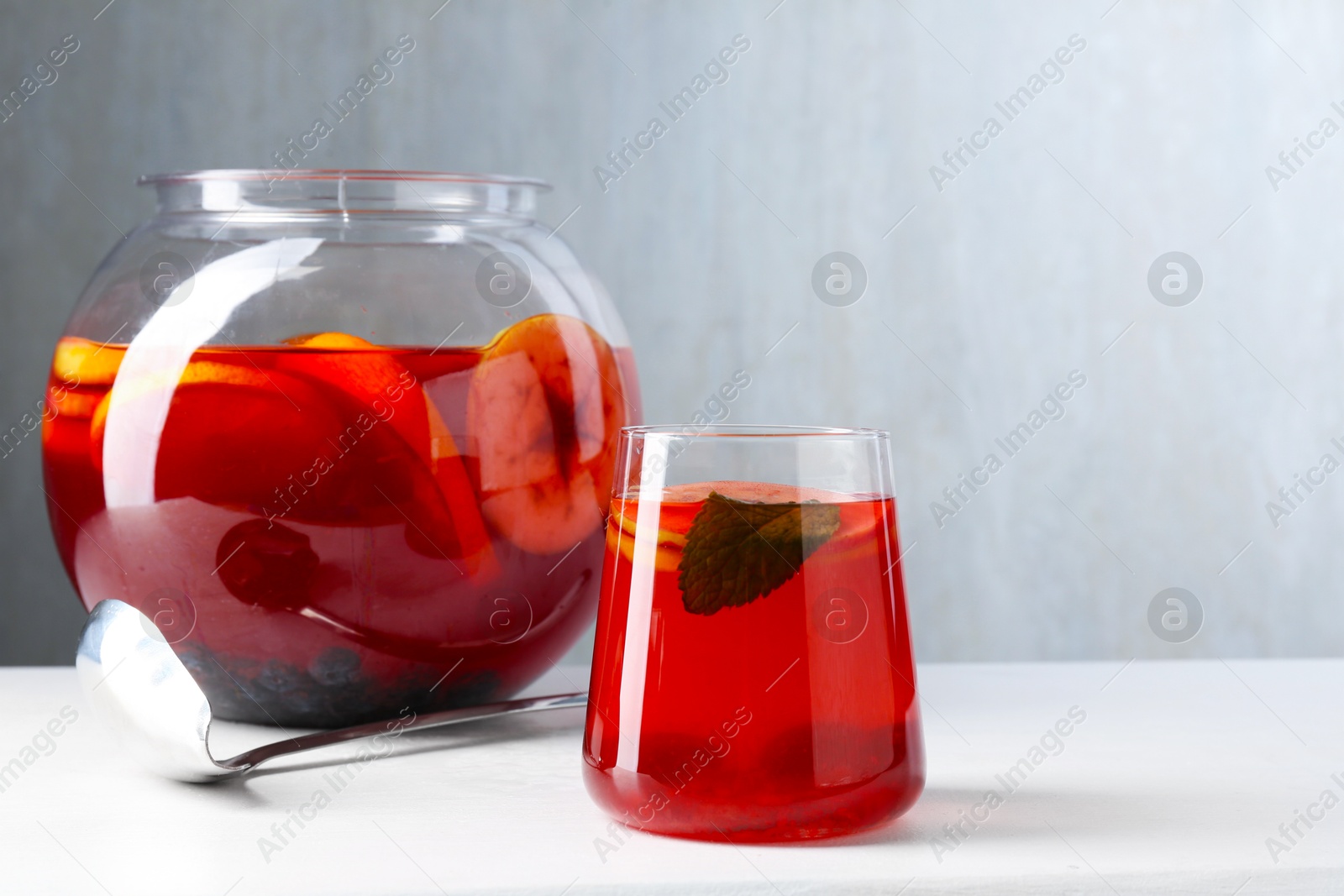 Tasty fruity punch on white table, space for text. Refreshing drink Photo of Tasty fruity punch on white table, space for text. Refreshing drink