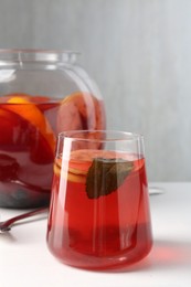 Photo of Tasty fruity punch on white table. Refreshing drink
