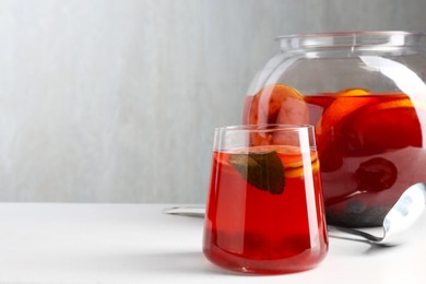 Photo of Tasty fruity punch on white table, space for text. Refreshing drink