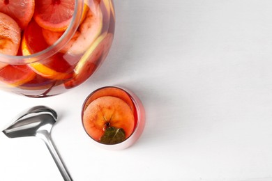 Photo of Tasty fruity punch on white table, top view with space for text. Refreshing drink